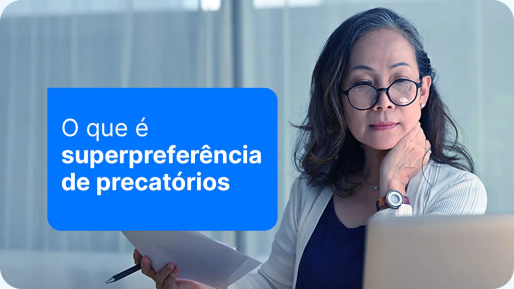 mulher analisando documentos e olhando para seu computador, solicitado a superpreferência de seu precatório
