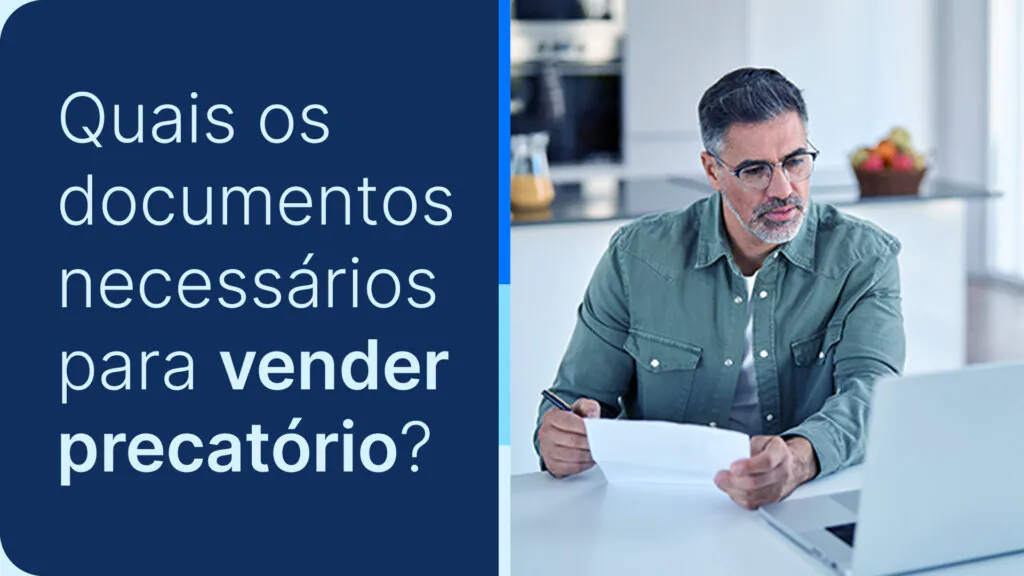 Homem analisando papéis e seu computador, ponderando sobre vender precatório